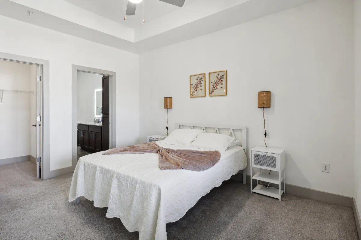 A tranquil bedroom setting with a plush bed, tasteful wall art, and nightstands framing the space, creating a sense of serenity and comfort for restful nights or relaxed mornings.