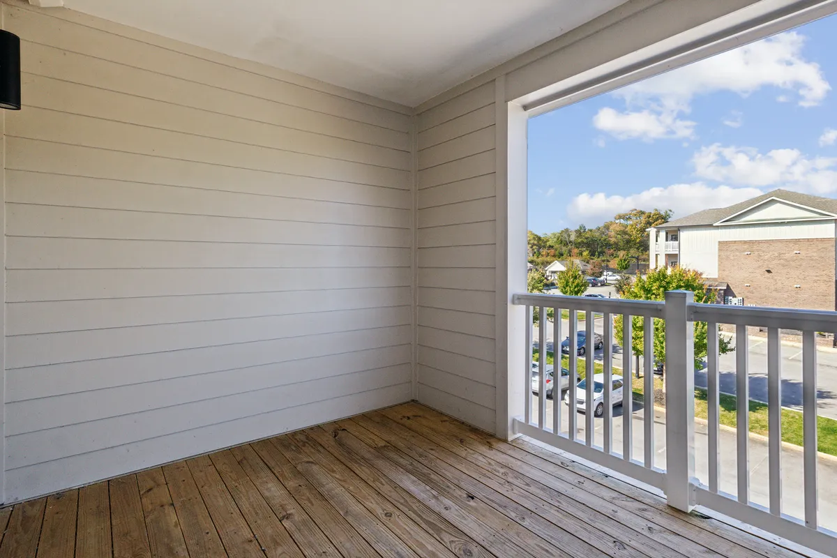 This living area features wooden flooring, an open window letting in natural light, and sturdy railings. The space is designed for relaxation, socializing, and enjoying tranquil moments, supporting gatherings and peaceful downtime.